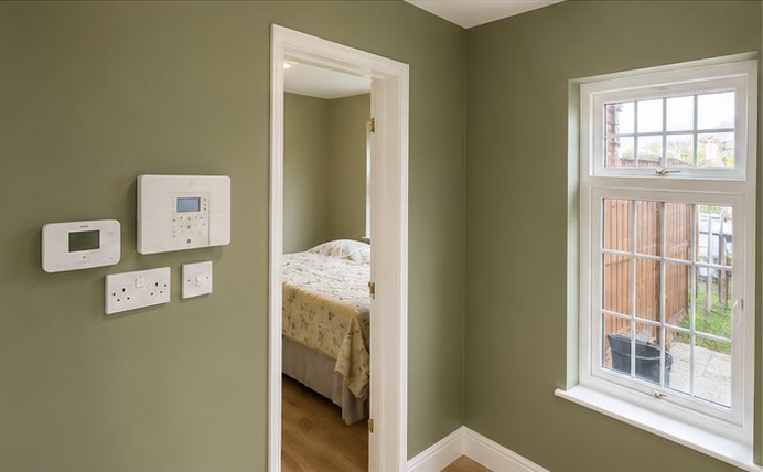 Sage green bedroom with white woodwork and sash window, Leicester